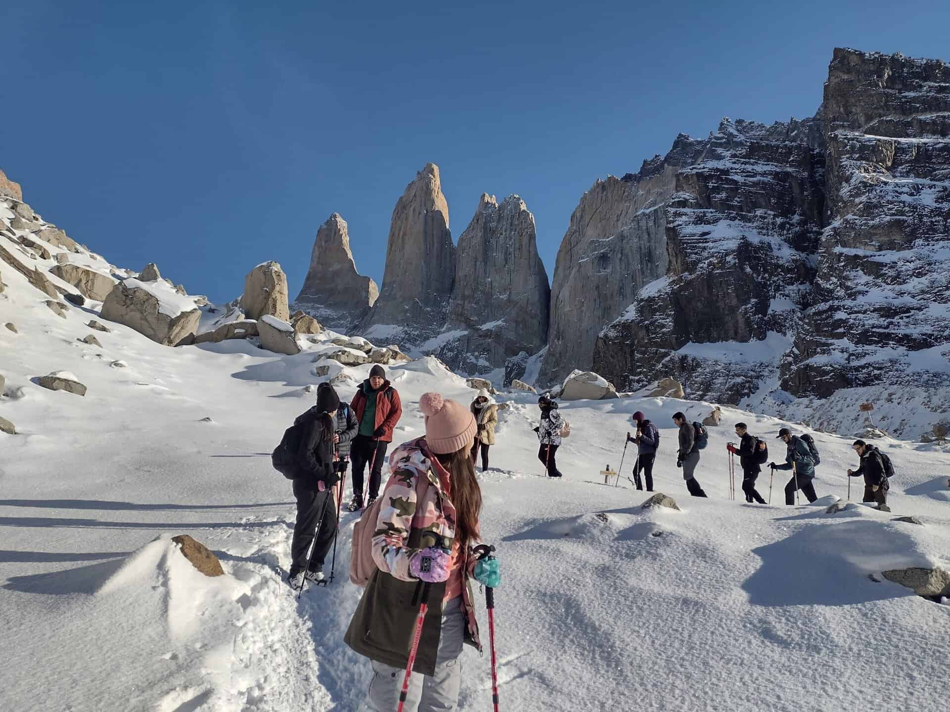 Torres del Paine winter guide leading small group to Base Torres with snow-covered granite towers and pristine winter landscape