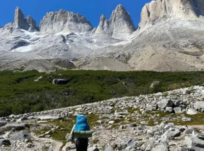 Solo female traveler hiking below the Torres del Paine mountains