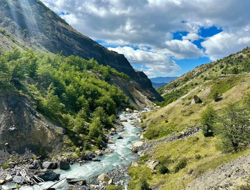 Ascencio Valley trail with river, forest, and mountain views on the way to Base Torres in Torres del Paine.