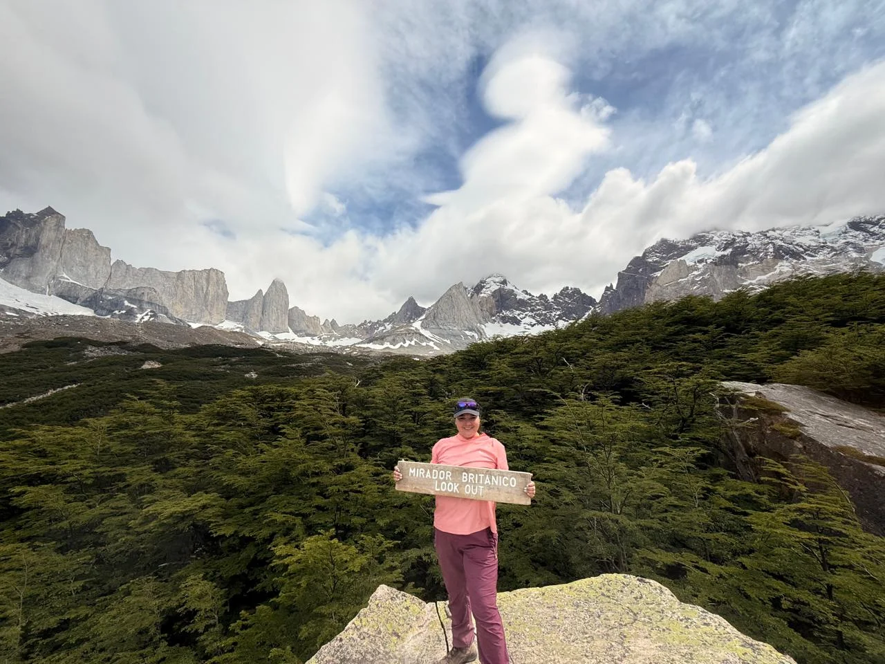Traveler at Mirador Británico in French Valley, surrounded by forest and mountain views in Torres del Paine.
