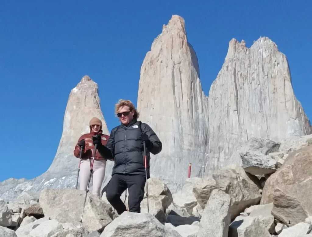 Travelers descending from the Base Torres viewpoint below the granite towers in Torres del Paine National Park.