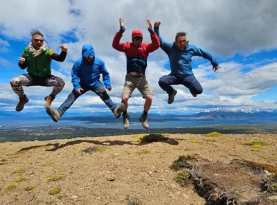Travelers jumping at a scenic viewpoint over Ultima Esperanza Fjord