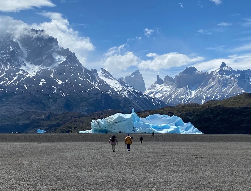 People walking along the shore of Lake Grey in Torres del Paine