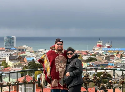 Travelers at a viewpoint overlooking Punta Arenas and the Strait of Magellan in southern Patagonia.