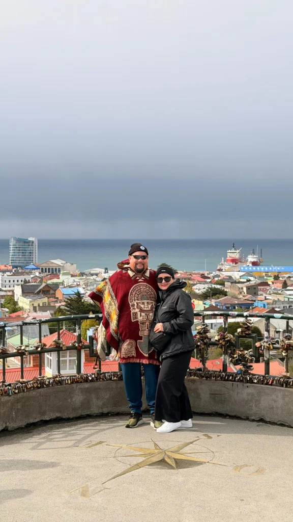 Travelers at a viewpoint overlooking Punta Arenas and the Strait of Magellan in southern Patagonia.