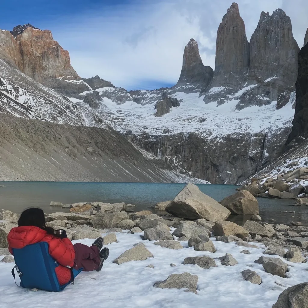 Hiker resting at the Base Torres viewpoint after the climb on the W Trek, Torres del Paine