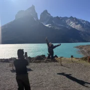 Hiker with open arms at Lake Pehoé, the Cuernos del Paine behind