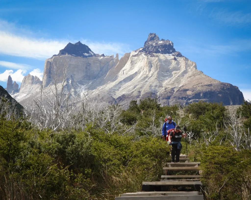 Hiker with a backpack on the boardwalk below the Cuernos del Paine
