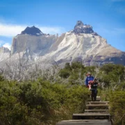 Hiker with a backpack on the boardwalk below the Cuernos del Paine