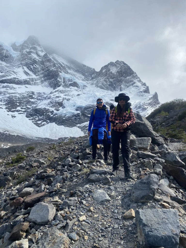 Hikers on the rocky trail into the French Valley on the W Trek, Torres del Paine, with the Paine Grande glaciers above